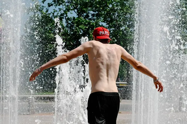 Un joven sin camiseta y una gorra al revés que dice París