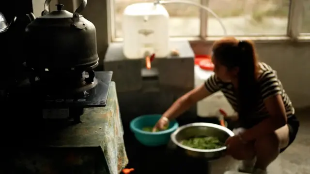 Une femme à l'intérieur d'un appartement dans un immeuble inachevé en Chine.