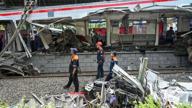 Petugas mengevakuasi gerbong KRL Commuterline usai bertabrakan dengan KA Argo Bromo Anggrek relasi Gambir-Surabaya Pasar Turi di Stasiun Bekasi Timur, Bekasi, Jawa Barat, Selasa (28/04).