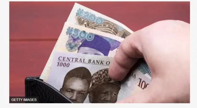 Aworan ọwọ to n ko owo naira jade.