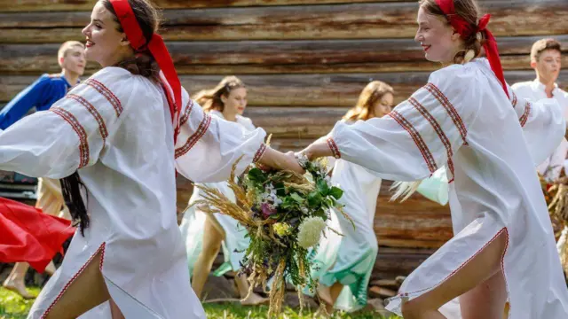 Ужгород, дівчата в білих вишитих довгих сорочках, з оголеними ногами танцюють хоровод.