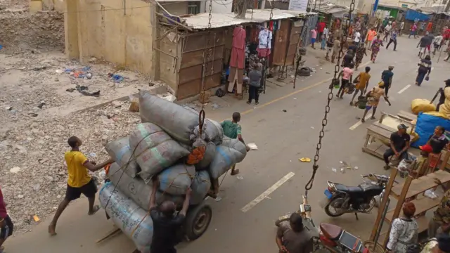 Ndị ahịa bu ngwaahịa ha na-agagharị n'ime ahịa Onitsha Main Market.