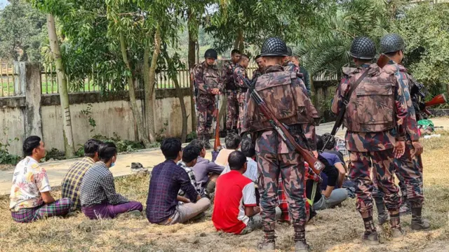 ထွက်ပြေးလာတဲ့ မြန်မာနယ်ခြားစောင့်တပ်ဖွဲ့ဝင်(ထိုင်နေကြသူများ)တွေကို စောင့်ကြပ်နေတဲ့ ဘင်္ဂလား‌ဒေ့ရှ် နယ်ခြားစောင့်တပ်ဖွဲ့ဝင်တွေ 