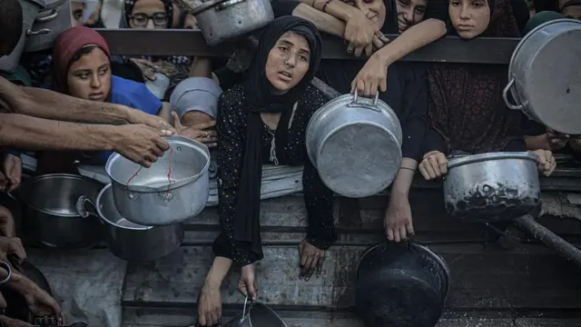 Un grupo de mujeres palestinas esperan agolpadas en Gaza a que les entreguen ayuda humanitaria. 