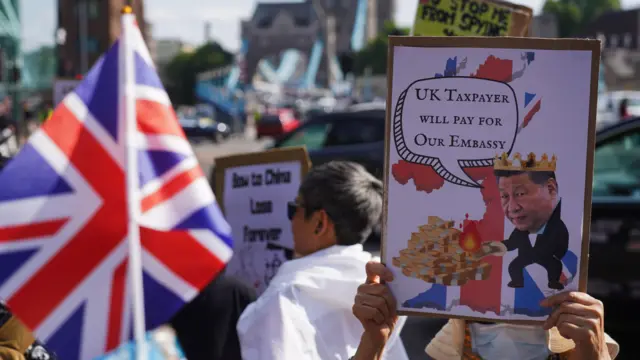 倫敦前皇家鑄幣廠外一名示威者舉起反對中國「超級大使館」的標語牌(14/6/2025)