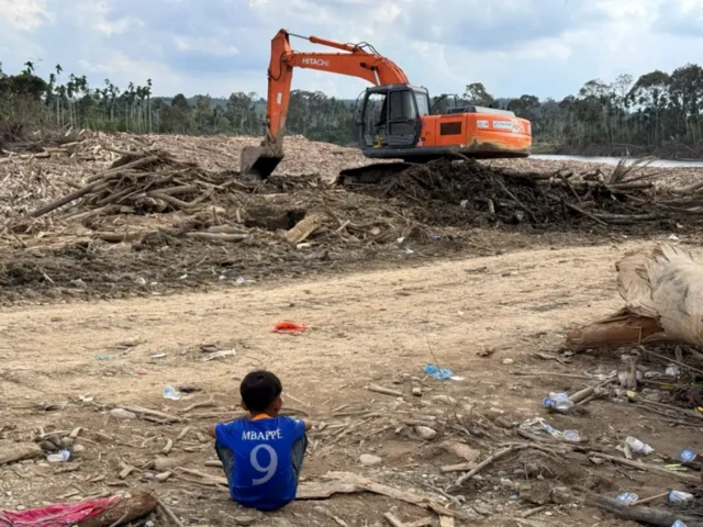 Eskavator tengah membersihkan gelondongan kayu di Desa Geudumbak, Kecamatan Langkahan, Kabupaten Aceh Utara.