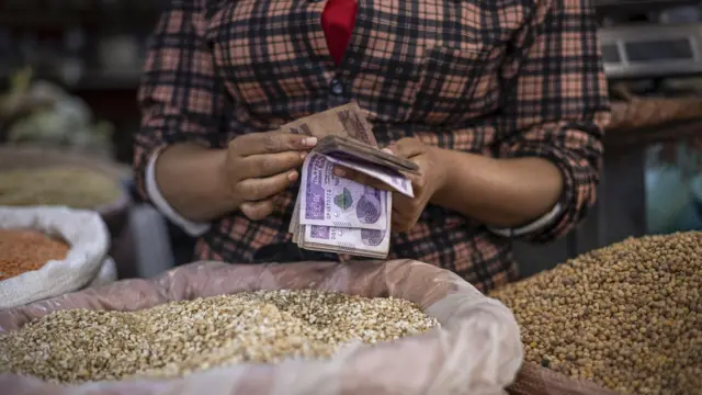 የስንዴ መሸጫ ላይ ብር የምትቆጥር ሴት እጅ