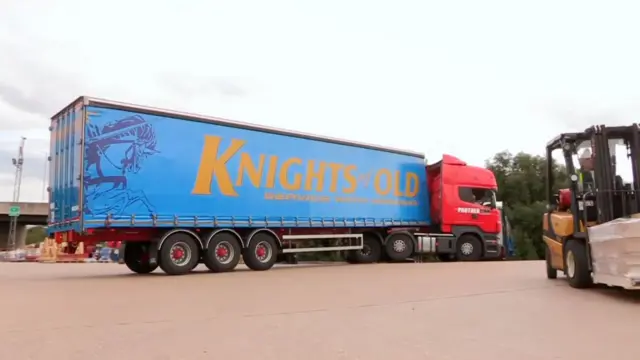 A large red and blue truck wit words 'Knights of Old' and 'Service wit Honour' wey dem write on di body