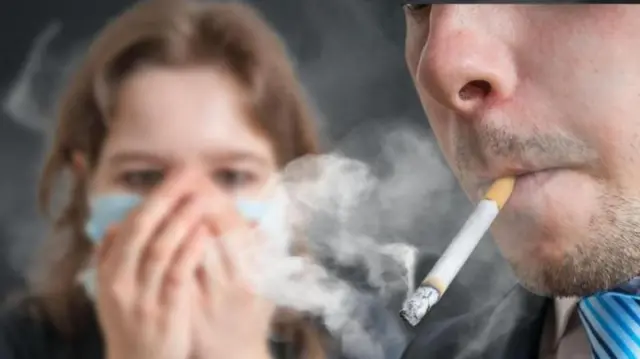 सिगारेट ओढणारा व्यक्ती आणि महिला 