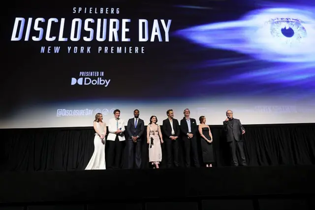 El elenco de la película está frente a una gran pantalla de cine, en la que se ve el título de la película. Es Steven Spielberg quien tiene el micrófono y se dirige a los asistentes a la premier de la película, momentos antes de que arranque.