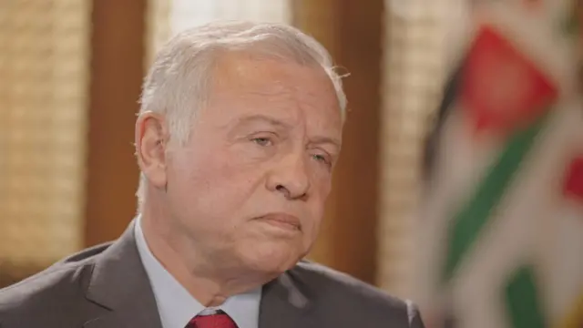 Rei Abdullah da Jordânia veste terno cinza e gravata vermelha. Ele olha atento enquanto dá entrevista para à BBC.