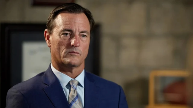 Мужчина средних лет в синем пиджаке с галстуком