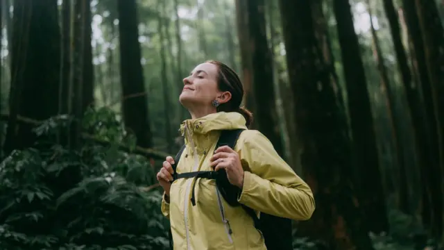 Mujer contemplando en el bosque.