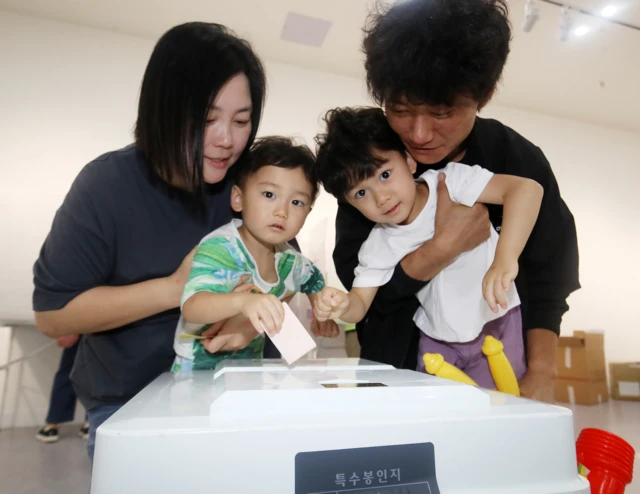 제9회 전국동시지방선거 및 국회의원 재·보궐선거일인 3일 부산 부산진구청에 마련된 부암제1동제4투표소에서 유권자들이 아이들과 함께 투표를 하고 있다. 