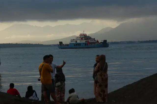 Warga melihat proses pencarian korban tenggelamnya KMP Tunu Pratama Jaya di Selat Bali, Banyuwangi, Jawa Timur, Kamis (03/07).