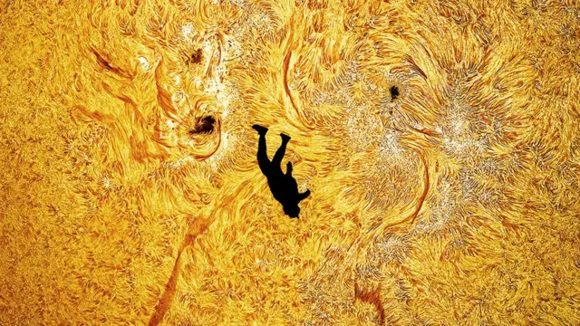 Silueta de un hombre en negro y el sol, con sus llamas, de fondo