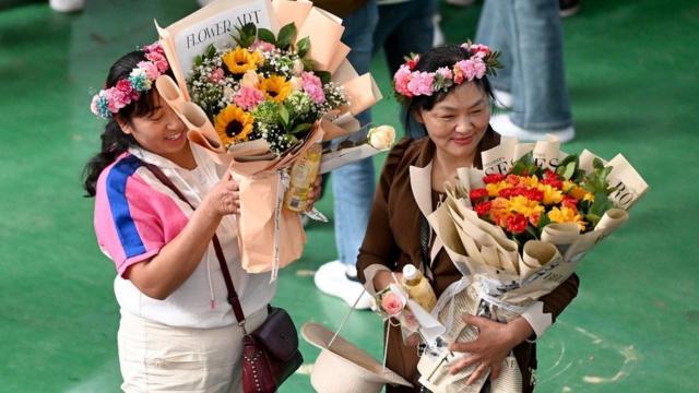 Femmes avec des bouquets de fleurs