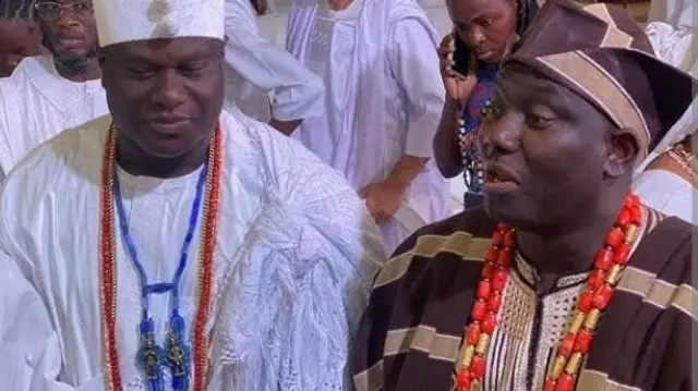 Aláàfin Abimbola Owoade wọ agbada àti Sokoto aláwọ̀ Kọfi àti Goolu, ó dé fìlà abeti ajá, ó fi ìlẹ̀kẹ̀ ńlá méjì sọrun, Ọọ̀ni Adeyeye Ogunwusi dúró sí ẹgbẹ́ Aláàfin, ó na ọwọ́ sókè bíi ọgbà to ń juwọ