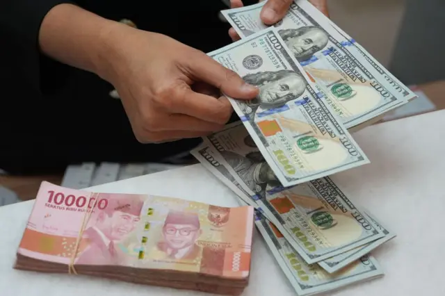 Uang kertas rupiah dan dolar AS di kantor penukaran mata uang di Jakarta.