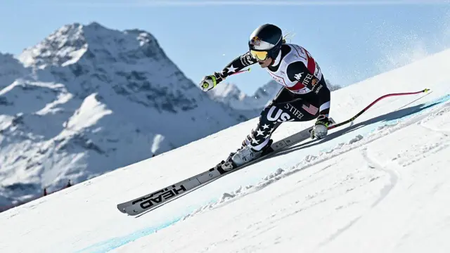 Американская горнолыжница Линдси Вонн несется по снежному склону на фоне гор