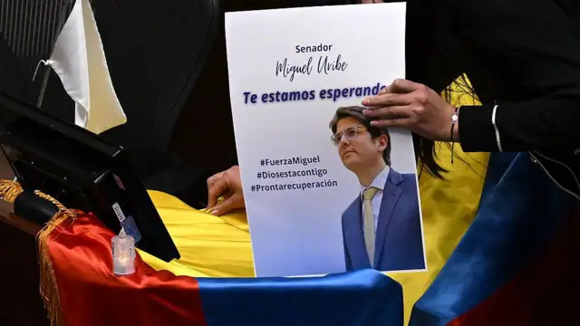 Uma mão segura cartaz com mensagem de apoio a Miguel Uribe, baleado durante um comício na Colômbia