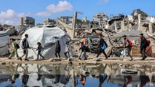 空爆で破壊された街並みの中を歩くパレスチナの子供たち