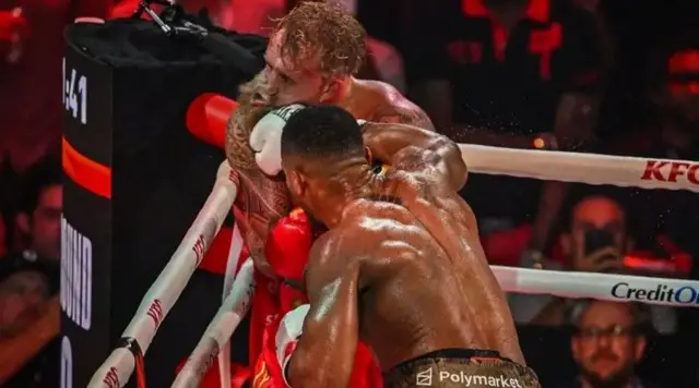 Joshua portant le coup décisif à Jake Paul, sur un ring.
