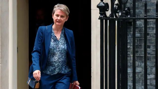 Иветт Купер выходит из резиденции премьер-министра в синем костюме