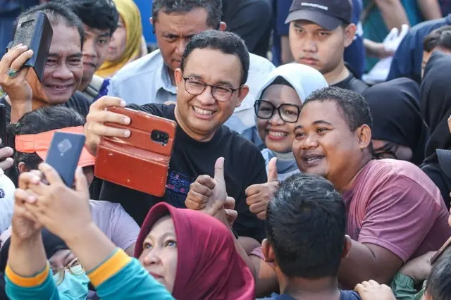 Mantan Gubernur DKI Jakarta Anies Baswedan (kiri) berswafoto dengan warga saat Hari Bebas Kendaraan Bermotor (HBKB) di Jl. Jend. Sudirman, Jakarta, Minggu (04/08)).