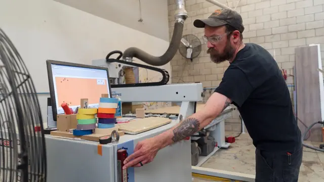 Чоловік біля верстату з ЧПК