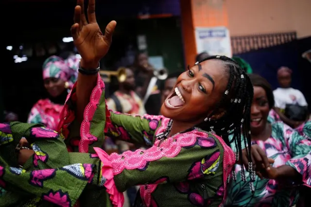 Umugore wasamye aseka uri kumwe n'abandi bagore