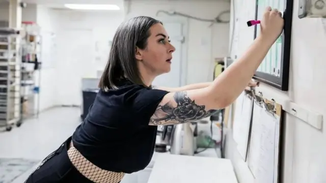 Une femme écrivant sur une affiche de bureau.