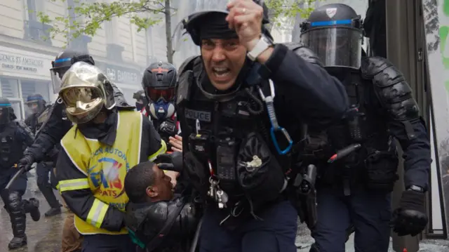 Paris'te yaralanan bir polis, meslektaşları tarafından taşınıyor