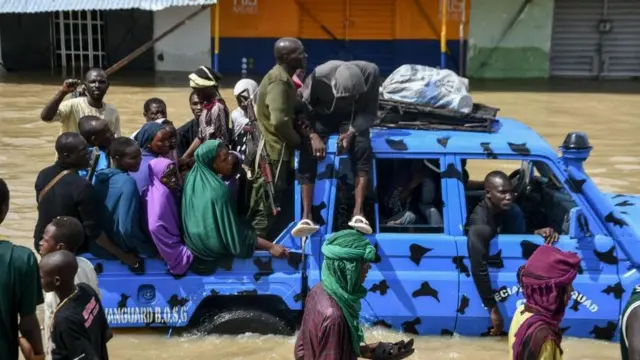 Des personnes touchées par les inondations sont escortées à bord d'un véhicule militaire à Maiduguri.