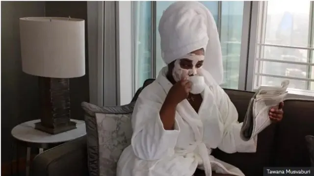 Tawana ari gusoma ikinyamakuru ndetse ananywa icyayi mu itasi y'umweru