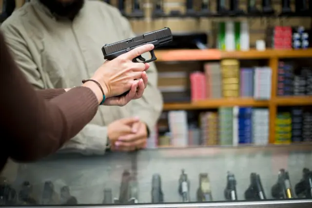 Una persona sostiene un arma de fuego.