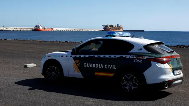 Un coche de la Guardia Civil en el puerto que espera al buque.