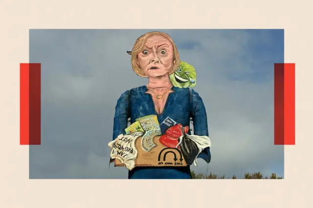 青いワンピース姿のトラス氏が、私物を入れた段ボール箱を抱えている様子を描いた絵画。肩には、泣き笑いするレタスがのっている。