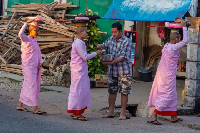 အမျိုးသားတစ်ဦးက သီလရှင်တွေကို ဆန်လှူဒါန်းနေတဲ့မြင်ကွင်း 