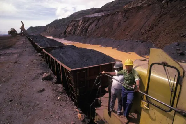 Trabalhadores venezuelanos em um trem carregado de minério de ferro no Estado venezuelano de Bolívar
