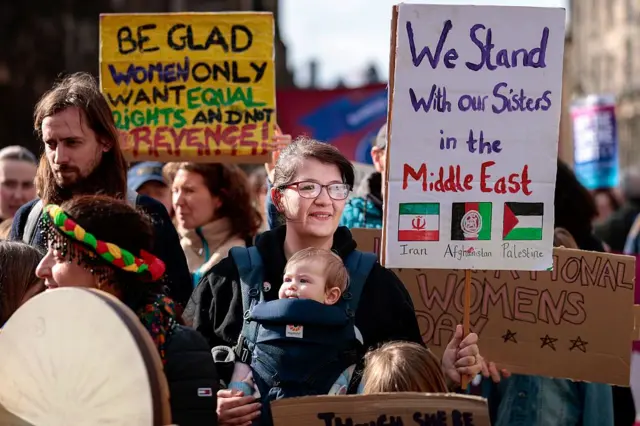 Miembros del público participan en una marcha para conmemorar el Día Internacional de la Mujer el 8 de marzo de 2026 en Edimburgo, Escocia.
