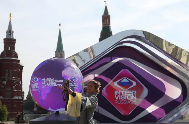 Жінка робить селфі перед інсталяцією, присвяченою музичному конкурсу Інтербачення, у парку "Заряддя" неподалік Кремля у сонячний осінній день у Москві, Росія, 17 вересня 2025 року.