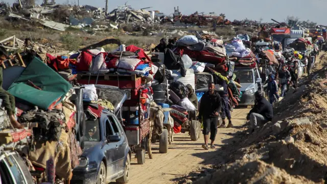 Palestinos deslocados fazem fila para que seus veículos e carroças sejam inspecionados em um posto de controle na estrada para o norte de Gaza