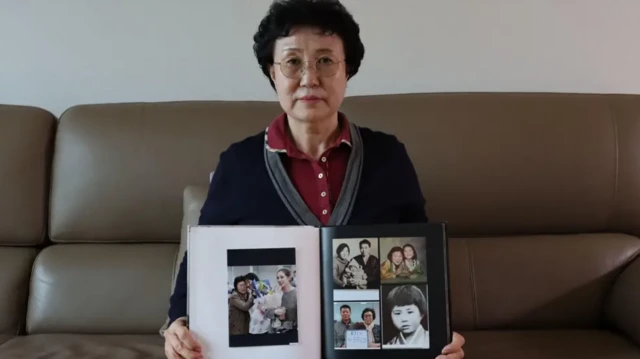 هان تایسون روی مبل نشسته و آلبوم عکسی را رو به دوربین گرفته است