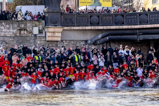 Македонци скачу у хладну воду да би ухватили крст који је у реку Вардар бацио поглавар Македонске православне цркве, архиепископ Стефан, током прославе Богојављења у Скопљу, Република Северна Македонија, 19. јануара 2026. Млади Македонци скачу у ледену воду док се такмиче да ухвате крст у реци Вардар у Скопљу на Богојављење. 