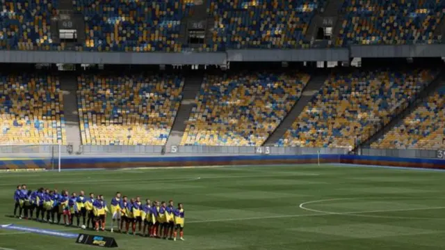 بازیکنان دو تیم قبل از آغاز بازی برای شنیدن سرود ملی و سخنان رئیس‌جمهوری اوکراین صف کشیدند