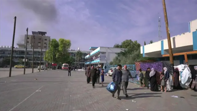 UNRWA school with smoke rising in the background