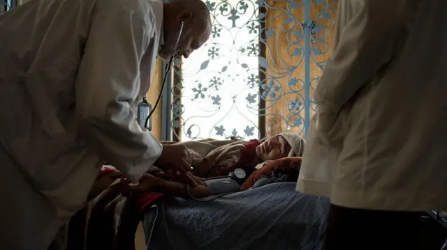 دو داکتر در اتاق ترک اعتیاد مرکز «نجات» – نهادی غیردولتی که به درمان و بازتوانی معتادان افغان، از جمله کسانی که با ویروس اچآیوی زندگی میکنند، کمک میکند – فشار خون یک معتاد به هروئین را اندازه میگیرند. این تصویر در ۲۴ اپریل ۲۰۱۲ در کابل گرفته شده است.