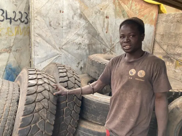 Modou devant les pneus qu'il revend