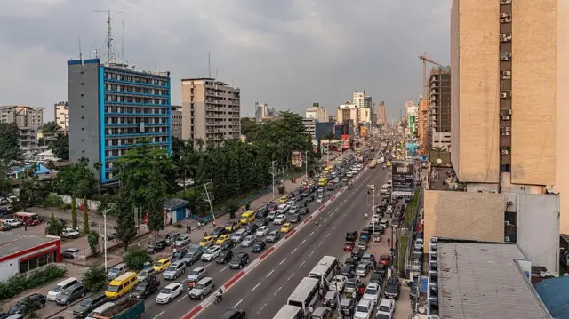 Surrounded by high-rise buildings, Kinshasa's Boulevard du 30 Juin is busy with traffic.